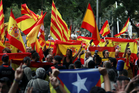 Protesters against a banned referendum on independence in Catalonia hold Spanish flags as a pro-independence demonstrator (front) displays an Estelada (Catalan separatist flag) during a demonstration in Barcelona, Spain, September 22, 2017. REUTERS/Susana Vera