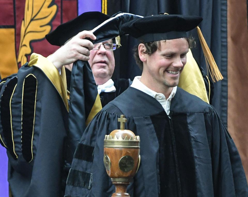 Chris Brown, right, alumni, receives an honorary degree from President Evans Whitaker during the Anderson University commencement on the school's front lawn in Anderson, S.C. Friday, May 3, 2024. Brown, a worship leader at Elevation Church, also honored with music industry awards including GMA Dove Awards and a Grammy, spoke to graduates about remembering the experience of learning at Anderson University.