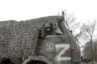 A serviceman waves from a military truck parked in a street in Mykolaivka, Donetsk region, the territory controlled by pro-Russian militants, eastern Ukraine, Sunday, Feb. 27, 2022. Fighting also raged in two eastern territories controlled by pro-Russia separatists. (AP Photo)