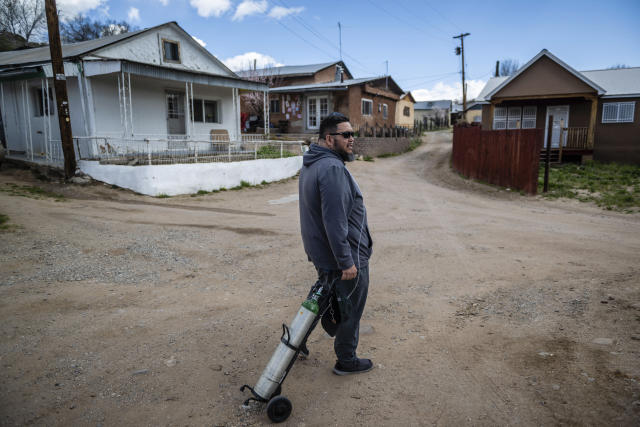 Angelo Sandoval, 'mayordormo' or caretaker of the 1830s San Antonio Church, stands on a dirt road in Cordova, New Mexico, Friday, April 14, 2023. "The dialect we speak is dying out. We're the last generation that learned it as first language," said Sandoval, 45. (AP Photo/Roberto E. Rosales)