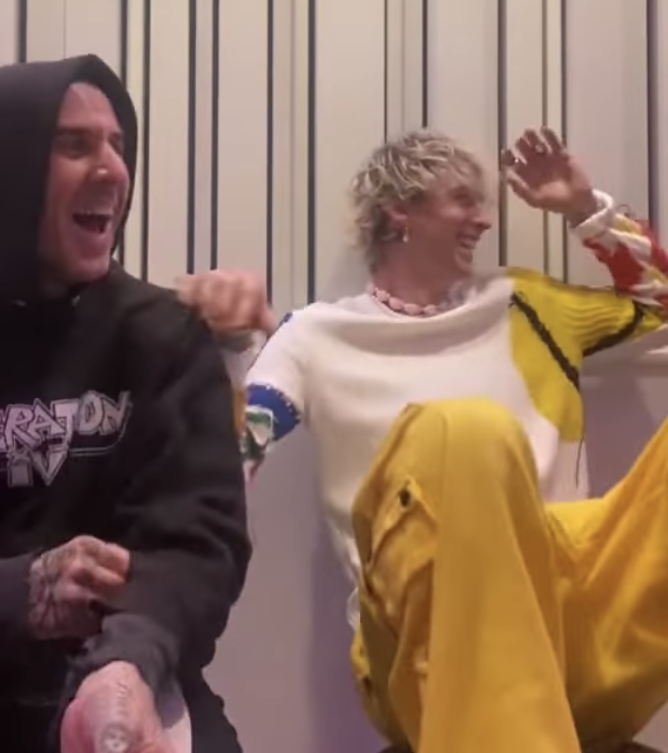 Travis Barker and MGK laughing on a couch