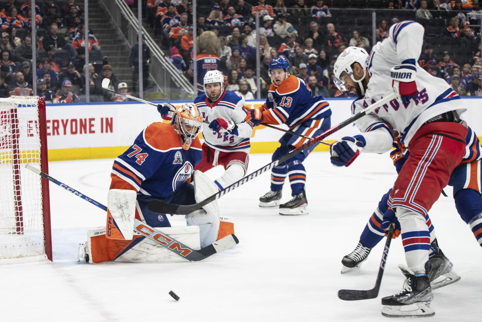 New York Rangers' K'Andre Miller (79) is stopped by Edmonton Oilers goalie Stuart Skinner (74) during the third period of an NHL hockey game Thursday, Oct. 26, 2023, in Edmonton, Alberta. (Jason Franson/The Canadian Press via AP)