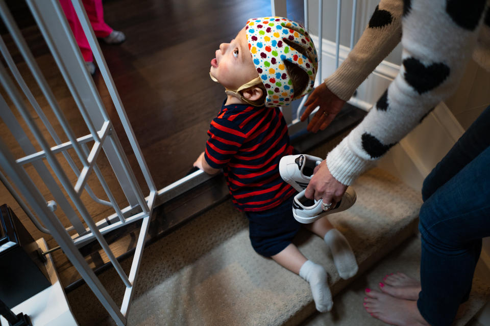 Maxwell Freed, who suffers from a rare genetic neurological disease, is helped to the top of a set of stairs at his home in Denver. Climbing the stairs is a new accomplishment for Maxwell, whose disease has delayed his physical and mental development. (Photo: Autumn Parry for HuffPost)