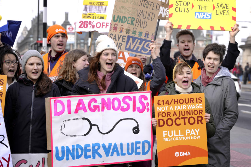 FILE - Junior doctors hold placards as they stand at a picket line outside St Thomas' Hospital in Westminster in London, Monday, March 13, 2023. Waiting times to diagnose and treat cancer across the U.K. have worsened in recent years and are at near record highs. Experts say too many cancers are diagnosed too late, and survival for common cancers in the U.K. consistently lags behind countries with similar universal health care systems. Many couldn't help comparing the swift treatment King Charles III received with how ordinary Britons fare at public hospitals. Experts say years of under-investment and staff shortages must be tackled. (AP Photo/Kirsty Wigglesworth, File)