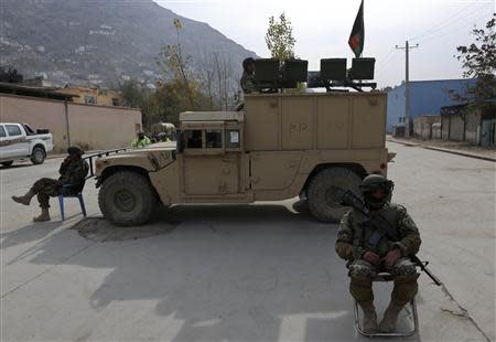 Afghan National Army (ANA) soldiers keep watch near a building in which the Loya Jirga (or grand council) is holding a committee session, in Kabul November 22, 2013. REUTERS/Omar Sobhani