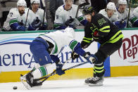 Dallas Stars center Tyler Seguin (91) and Vancouver Canucks defenseman Jack Rathbone (3) vie for control of the puck during the first period of an NHL hockey game in Dallas, Saturday, March 25, 2023. (AP Photo/LM Otero)