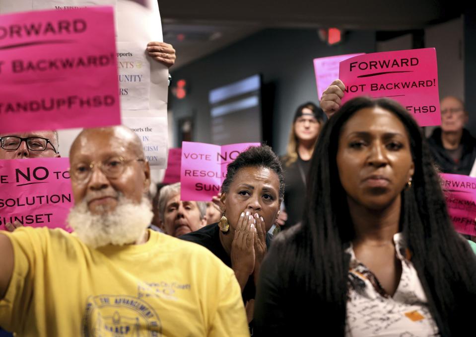 Kimberly Thompson, center, listens as Francis Howell School Board members talk in favor of rescinding all previously passed resolutions, including an anti-racism resolution, during a meeting on Thursday, July 20, 2023 in O'Fallon, Mo. In the national reckoning that followed the police killing of George Floyd three years ago, protesters took to the streets in a St. Louis suburb and urged the mostly-white Francis Howell School District to address racial discrimination. The school board responded with a resolution promising to do better. Now, led by new conservative board members elected since last year, that resolution has been revoked.(David Carson/St. Louis Post-Dispatch via AP)