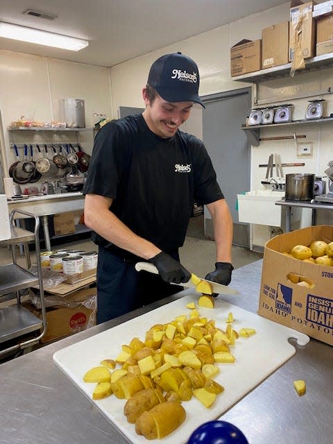 Nick Friedmeyer, a cook with Nelson's Catering in Springfield, cuts up some Yukon Gold potatoes Friday, Aug. 18, 2023 for a wedding in Mt. Zion Saturday. Nelson's is among 12 Sangamon County restaurants that will receive thousands of dollars in grant money from the state of Illinois through their Back to Business grants.