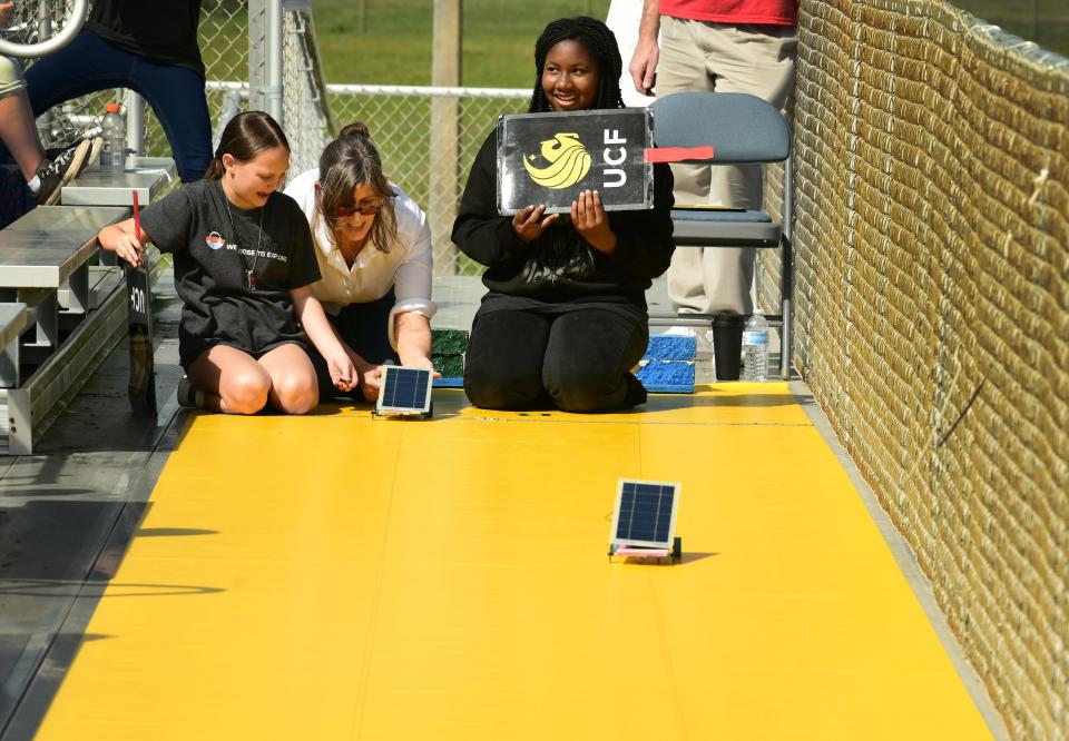 Solar Rover races were held at the Viera High track as part of Destination Mars. Left to right, Lila Coffrin, of Riviera Elementary, Susan Schleith, volunteer with Florida Solar Energy Center, and Kayla Humphrey of Cambridge Elementary.