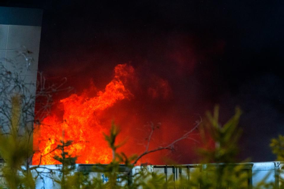 A massive fire burns inside a Walmart fulfillment center in Plainfield, Ind., near the Indianapolis International Airport.