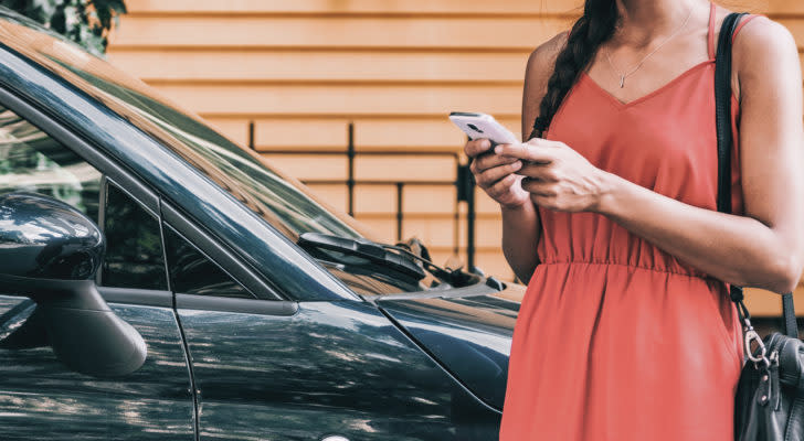 A woman hails a ride through her mobile phone.