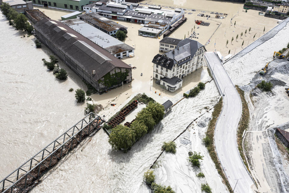 A view of the Rhone river, at left, and the Navizence river overflowing in the industrial zone that produces aluminium "Constellium," following the storms that caused major flooding, in Chippis, Switzerland, Sunday, June 30, 2024. The Rhone river burst its banks in several areas of Valais canton, flooding a highway and a railway line. (Olivier Maire/Keystone via AP)