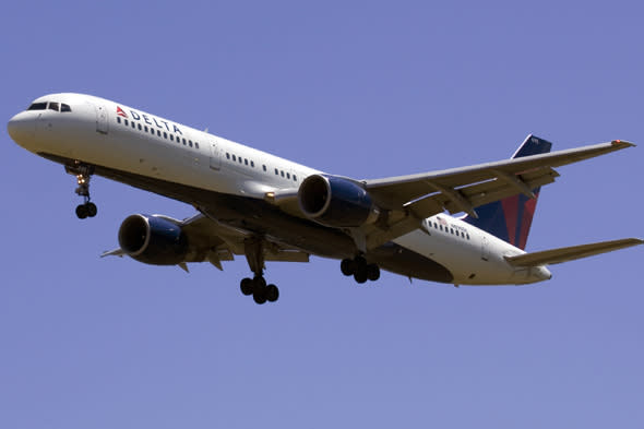 A Delta Airlines plane flies into Portland International Airport in Portland, Ore., Monday, July 20, 2009. The Atlanta-based company, which is the world's biggest airline operator, is expected to post a loss for the April-June quarter. Delta Air Lines Inc., the world's biggest airline operator, said Wednesday, July 22, it narrowed its second-quarter net loss to $257 million.(AP Photo/Don Ryan)