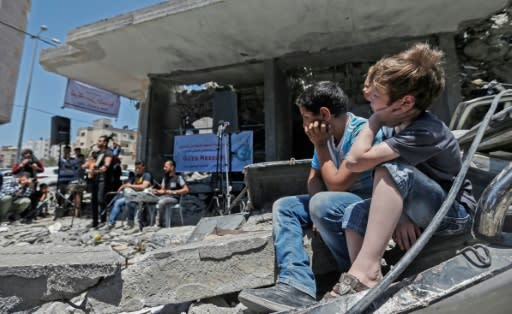 Palestinian children watch musicians perform in the shadow of a building destroyed by an Israeli air strike this month in response to Palestinian rocket fire