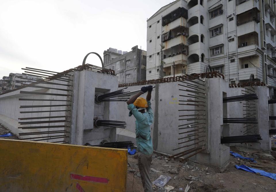 A laborer works on the construction of a flyover bridge in Hyderabad, India, Wednesday, Aug. 31, 2022. India’s economy grew by 13.5% in the April-June quarter from a year earlier, pushed up by a boost in agriculture and manufacturing as pandemic curbs eased, official figures released Wednesday show. (AP Photo/Mahesh Kumar A.)