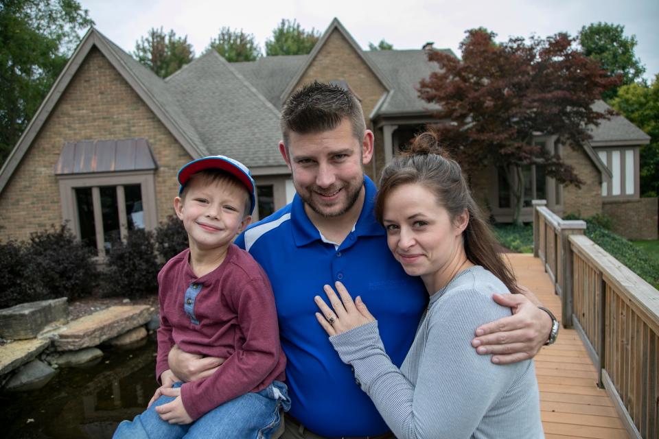 Jonathan Smith, 5, poses with his parents Andrew Smith, 35, and Sarah Smith, 33, at their new home in Rochester Hills Friday, Oct. 4, 2019. The Smith’s are homeowners who bought a new house through on of these "Buy this house, and we'll buy yours" programs. 

