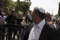 Israeli Knesset member Itamar Ben Gvir gives a victory sign as he argues with Palestinians during a visit to the Sheikh Jarrah neighborhood of East Jerusalem, Monday, May 10, 2021. (AP Photo/Sebastian Scheiner)