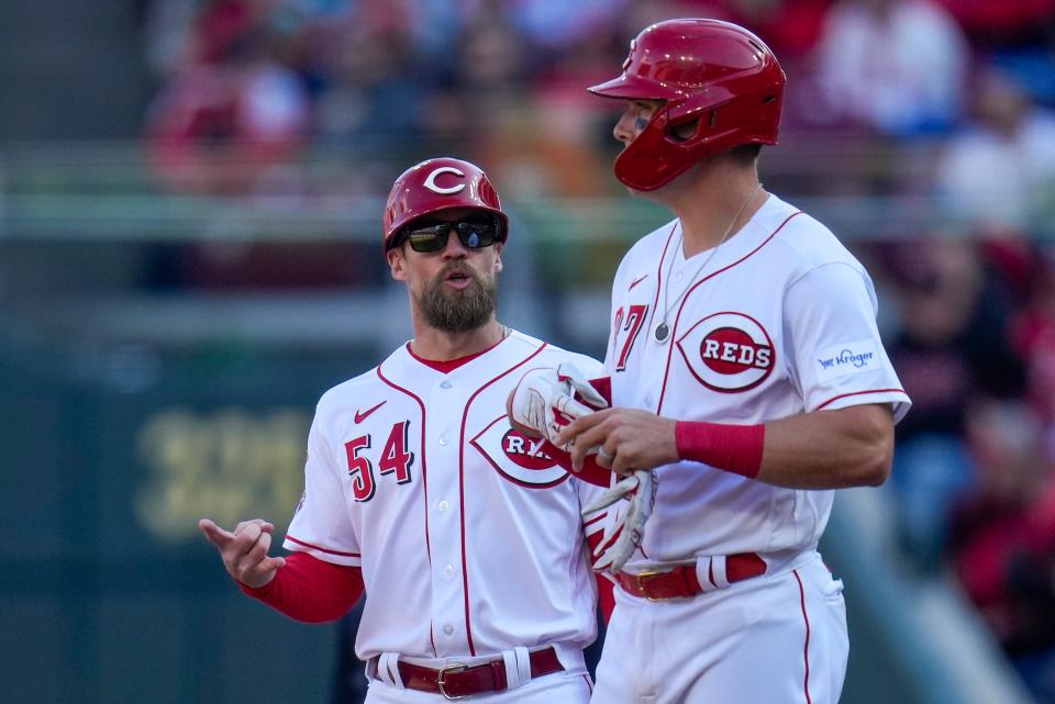 Cincinnati Reds first base coach Collin Cowgill talks with catcher Tyler Stephenson, who had a productive groundout to score a run on Opening Day.