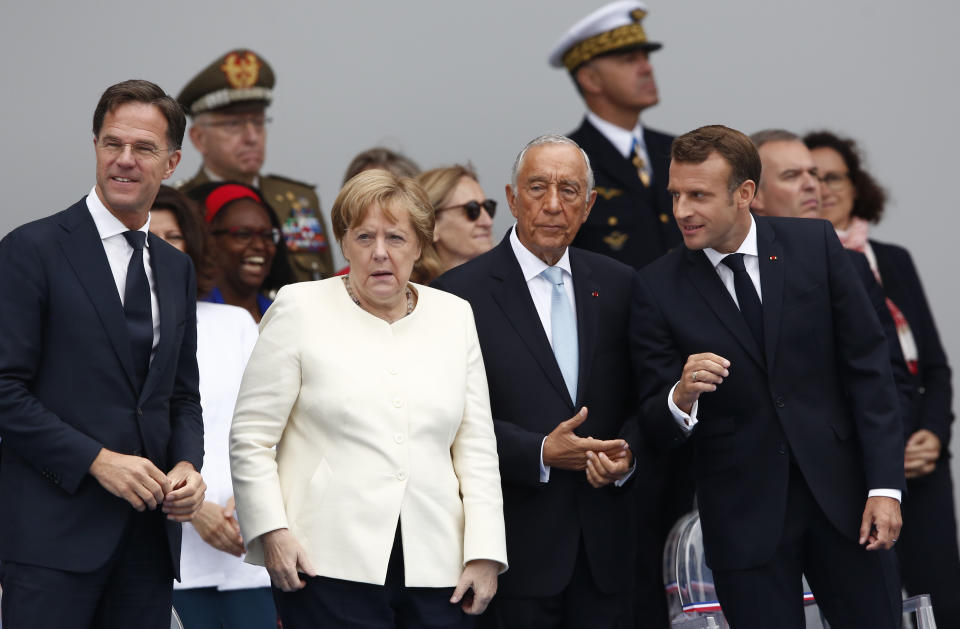 From the left, Dutch Prime Minister Mark Rutte, German Chancellor Angela Merkel, Portugal's President Marcelo Rebelo de Sousa and French President Emmanuel Macron, attend Bastille Day parade Sunday, July 14, 2019 on the Champs Elysees avenue in Paris. (AP Photo/Kamil Zihnioglu)