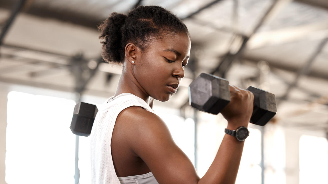  Woman lifts a dumbbell in the gym 