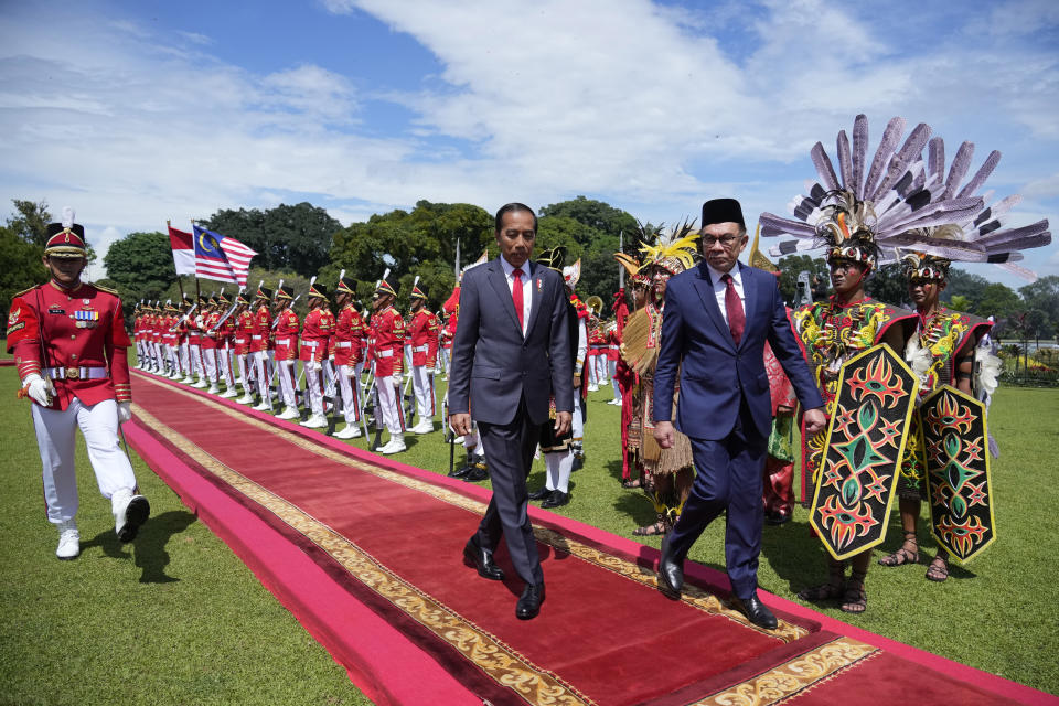 Malaysian Prime Minister Anwar Ibrahim, right, inspects honor guards with Indonesian President Joko Widodo during their meeting at the presidential palace in Bogor, West Java, Indonesia, Monday, Jan. 9, 2023. (AP Photo/Achmad Ibrahim)