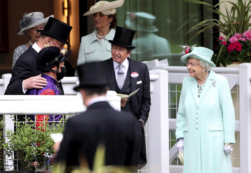 Britain's Queen Elizabeth II, right, talks to Frankie Dettori, left and trainer John Gosden, background left , during day five of of the Royal Ascot horserace meeting, at Ascot Racecourse, in Ascot, England, Saturday June 19, 2021. (David Davies/PA via AP)