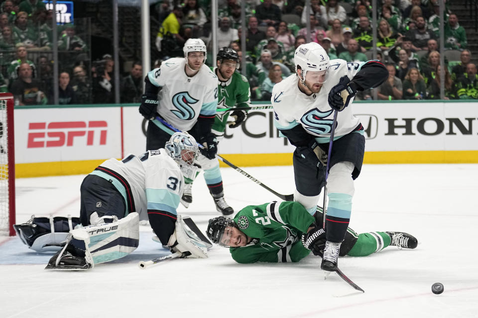 Dallas Stars left wing Mason Marchment, center, attempt to reach the puck in front of Seattle Kraken's Philipp Grubauer as defenseman Will Borgen, right, moves to take control in the first period of Game 1 of an NHL hockey Stanley Cup second-round playoff series, Tuesday, May 2, 2023, in Dallas. (AP Photo/Tony Gutierrez)
