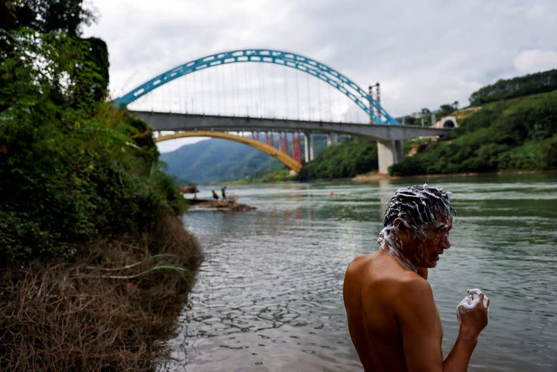 FILE PHOTO: A resident bathes in the Mekong river near Jinghong hydropower plant in Xishuangbanna Dai Autonomous Prefecture, Yunnan Province