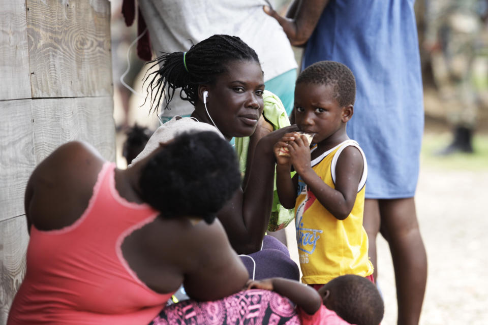 Women and children sit idle at a migrant camp amid the new coronavirus pandemic in Lajas Blancas, Darien province, Panama, Saturday, Aug. 29, 2020. In Lajas Blancas, the migrants did not wear masks or practice social distancing, but Panama's Public Security Minister Juan Pino said there have not been more than 10 infections among the migrants. (AP Photo/Arnulfo Franco)