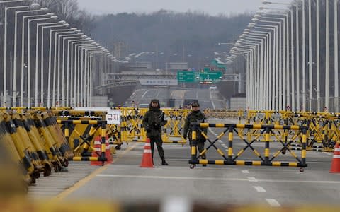 South Korean army soldiers stand guard on Unification Bridge, which leads to the demilitarized zone, near the border village of Panmunjom in Paju, South Korea - Credit: Ahn Young-joon/ AP