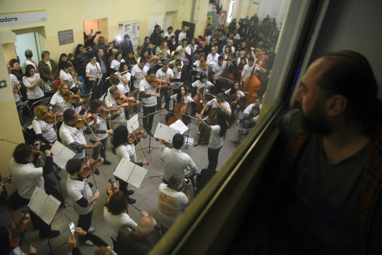 A man watches volunteer members of Musica Para el Alma (Music for the Soul) giving a flash mob concert in the main hall of the Alvarez Hospital in Buenos Aires in June