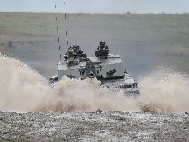 A Challenger II Main Battle Tank speeds through water at Royal Tank Regiment HQ, Tidworth, Wiltshire