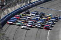 NASCAR Cup Series drivers line their cars up five wide in a salute to fans during pace laps for the NASCAR Cup Series auto race at Auto Club Speedway, in Fontana, Calif., Sunday, March 17, 2019. (AP Photo/Rachel Luna)