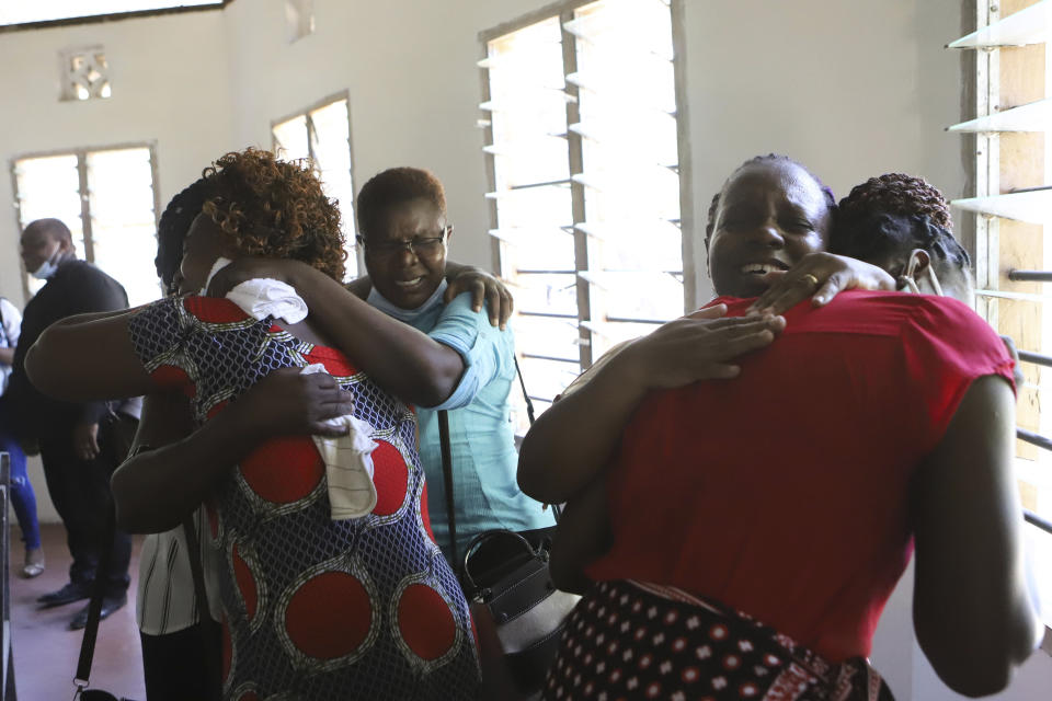 Family members grieves with other relatives as they wait to receive the bodies of victims of a religious cult for burial in Malindi Funeral home in Kilifi, Kenya Tuesday, March. 26, 2024. Kenya government on Tuesday released seven bodies of victims, who died due to starvation to their families for burial. Some 34 bodies, out of the 429 that were exhumed last year, were positively identified. (AP Photo/Andrew Kasuku)