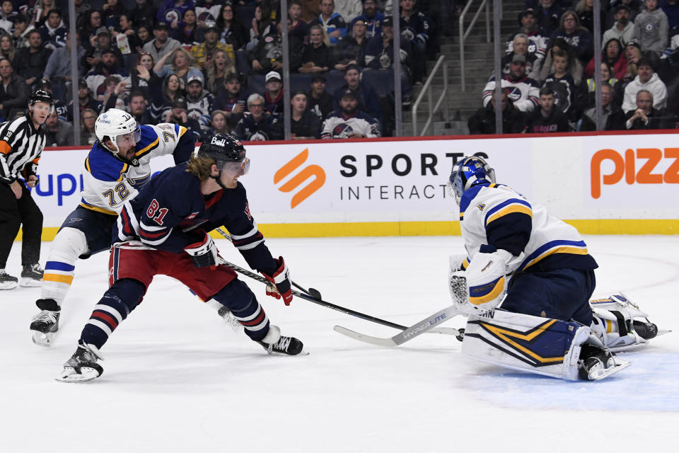 St. Louis Blues goaltender Thomas Greiss, right, makes a save against Winnipeg Jets' Kyle Connor (81) during the second period of NHL hockey game action in Winnipeg, Manitoba, Monday, Oct. 24, 2022. (Fred Greenslade/The Canadian Press via AP)