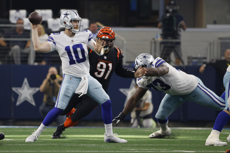 Dallas Cowboys quarterback Cooper Rush (10) tosses the ball as Cincinnati Bengals defensive end Trey Hendrickson (91) closes in during the second half of an NFL football game Sunday, Sept. 18, 2022, in Arlington, Tx. (AP Photo/Ron Jenkins)