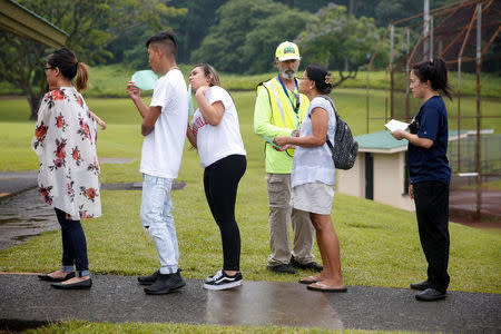 People wait in line for free dust masks in Keaau to protect themselves from volcanic ash during ongoing eruptions of the Kilauea Volcano in Hawaii, U.S., May 17, 2018. REUTERS/Terray Sylvester