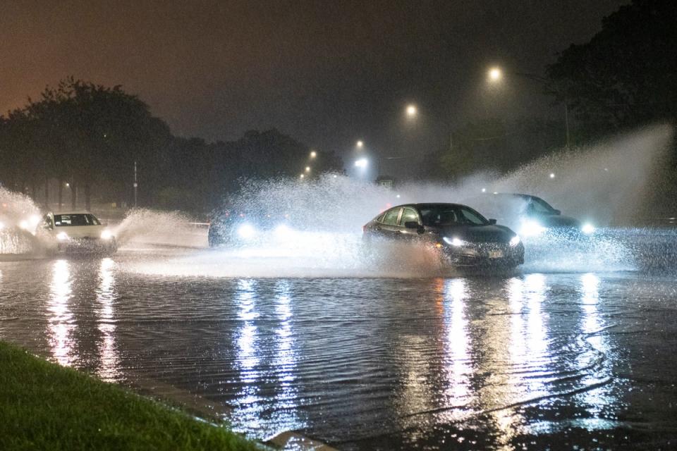 Cars drive through a flooded section of DuSable Lake Shore Drive as severe storms lash Illinois this week (AP)