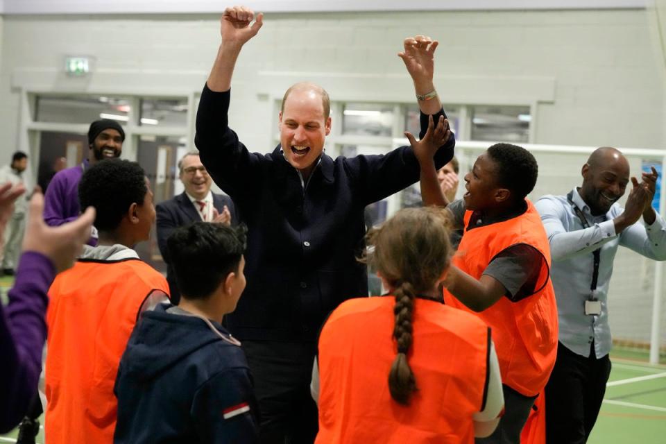 The Prince of Wales celebrates with young people after he threw a basket, during a visit to WEST, the new OnSide charity youth zone in Hammersmith and Fulham (Frank Augstein/PA Wire)