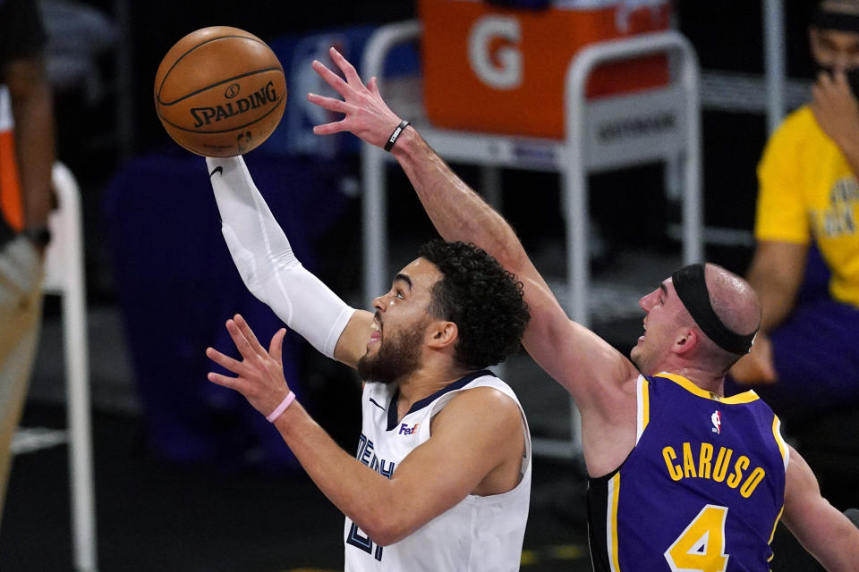 Memphis Grizzlies guard Tyus Jones, left, shoots as Los Angeles Lakers guard Alex Caruso defends during the first half of an NBA basketball game Friday, Feb. 12, 2021, in Los Angeles. (AP Photo/Mark J. Terrill)