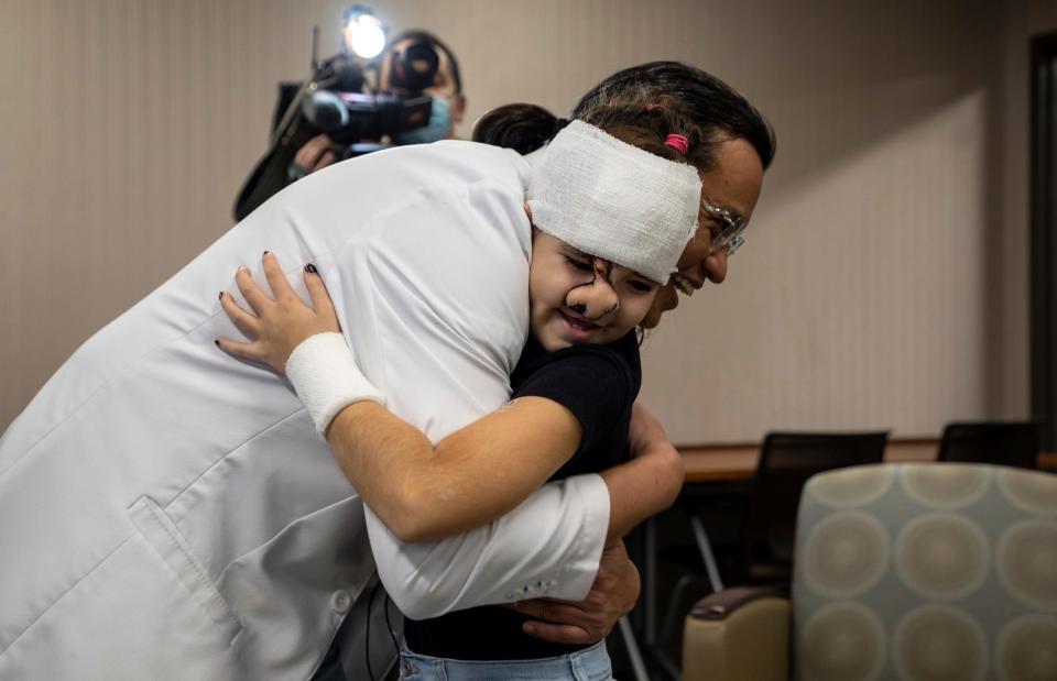 Dr. Kongkrit Chaiyasate, a plastic surgeon at Corewell Health William Beaumont University Hospital, hugs Aliz Cservenak inside the Beaumont Neuroscience Center in Royal Oak on Tuesday, Nov. 15, 2022. 