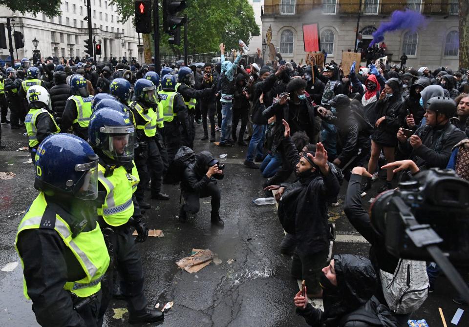 Police officers in riot gear form a line in front of protestors on Whitehall, near to Downing Street, in central London on June 6, 2020, during a demonstration to show solidarity with the Black Lives Matter movement in the wake of the killing of George Floyd, an unarmed black man who died after a police officer knelt on his neck in Minneapolis. - The United States braced Friday for massive weekend protests against racism and police brutality, as outrage soared over the latest law enforcement abuses against demonstrators that were caught on camera. With protests over last week's police killing of George Floyd, an unarmed black man, surging into a second weekend, President Donald Trump sparked fresh controversy by saying it was a "great day" for Floyd. (Photo by DANIEL LEAL-OLIVAS / AFP) (Photo by DANIEL LEAL-OLIVAS/AFP via Getty Images)