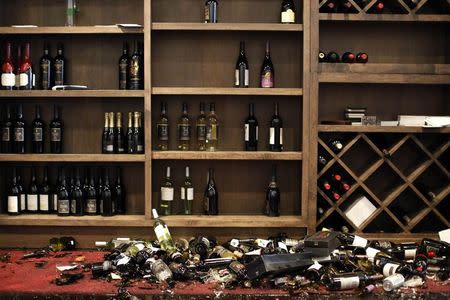 Fallen wine bottles are seen at Cult Following Wine Bar after an earthquake in Napa, California August 24, 2014. REUTERS/Stephen Lam