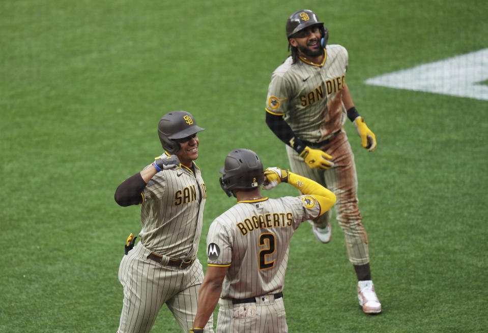 San Diego Padres' Juan Soto, left, celebrates his two-run home run against the Toronto Blue Jays with Xander Bogaerts (2) and Fernando Tatis Jr. during the first inning of a baseball game Tuesday, July 18, 2023, in Toronto. (Chris Young/The Canadian Press via AP)