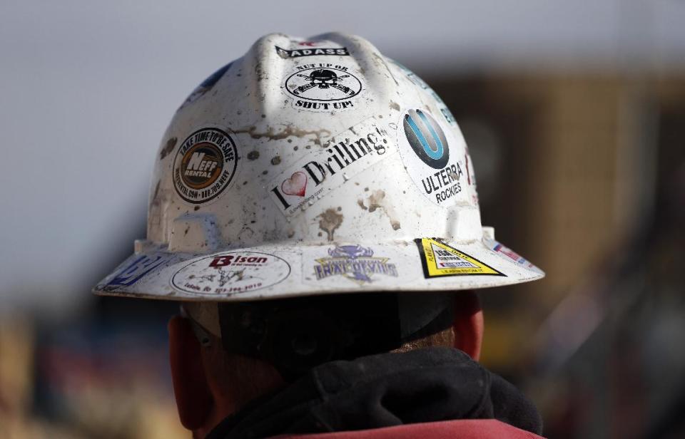 In this March 25, 2014 photo, a worker wears a protective helmet decorated with stickers during a hydraulic fracturing operation at a gas well, near Mead, Colo. The first experimental use of hydraulic fracturing was in 1947, and more than 1 million U.S. oil and gas wells have been fracked since, according to the American Petroleum Institute. The National Petroleum Council estimates that up to 80 percent of natural gas wells drilled in the next decade will require hydraulic fracturing. (AP Photo/Brennan Linsley)