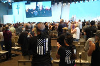 Members of the Trabuco Caynon community clap to thank law enforcement and first responders as they join in a prayer vigil to help families cope with the Cook's Corner shooting tragedy at the Saddleback Church in Lake Forest, Calif., Friday, Aug. 25, 2023. (AP Photo/Damian Dovarganes)