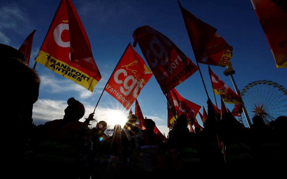 Protesters hold CGT labour union flags during a demonstration against French government's pension reform plan - REUTERS/Eric Gaillard