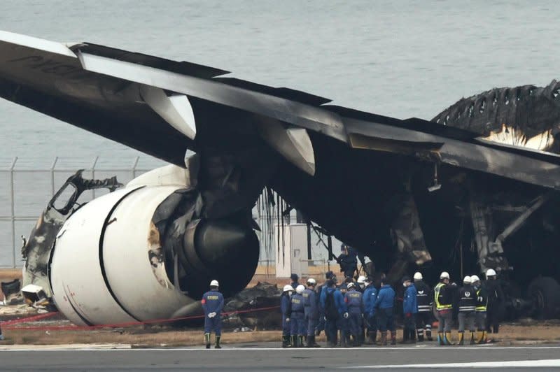 Tokyo Metropolitan Police investigators inspect the burnt wreckage of a Japan Airlines passenger plane Wednesday at Haneda Airport in Tokyo. The passenger plane carrying 367 passengers and 12 crew collided with a Japan Coast Guard plane transporting relief supplies for earthquake victims on Tuesday. Photo by Jiji Press Japan/EPA-EFE