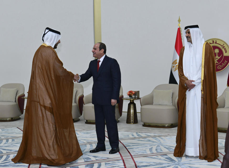 In this photo provided by Egypt's presidency media office, Egyptian President Abdel-Fattah el-Sissi, greets a Qatari official as he is accompanied by Qatari Emir Tamim bin Hamad Al Thani, right, in Doha, Qatar, Tuesday, Sept.13, 2022. Egypt’s president travelled on Tuesday to Qatar on his first visit to the gas-rich nation amid warming ties after years of frayed relations following the Egyptian military’s overthrow of an Islamist president backed by Doha. (Egyptian Presidency Media Office via AP)