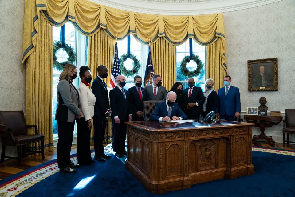 President Joe Biden signs an executive order in the Oval Office